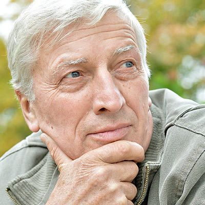 Older Man with hand on chin stoicly staring off in the distance