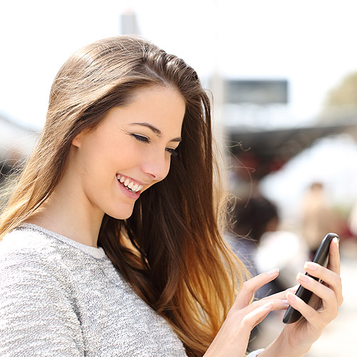 Young woman smiling at cell phone