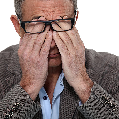 Older man rubbing his eyes