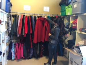 local woman choosing a coat at The Storehouse from the coats donated via the Focus On Community coat drive